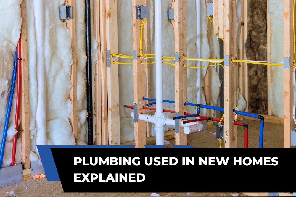 Exposed red and blue water supply pipes and white drainage piping installed between timber studs in an unfinished new home.